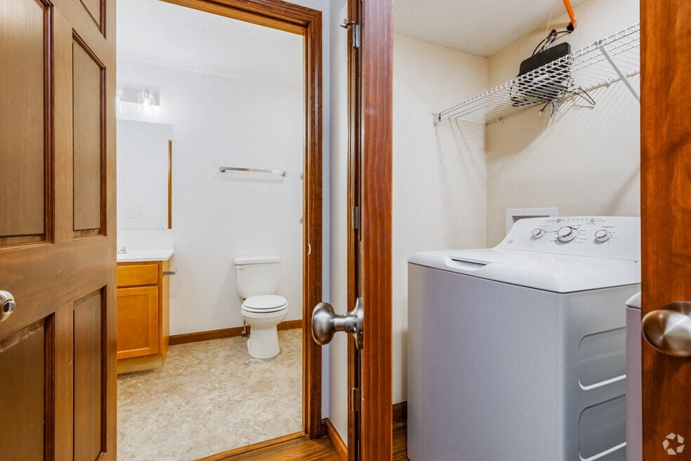 a laundry room with a washer and dryer and a bathroom with a toilet