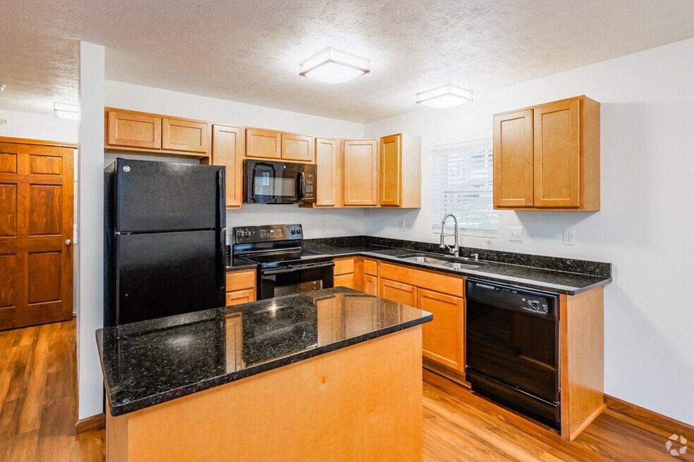 a kitchen with black appliances and wooden cabinets