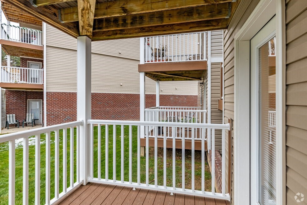 the view from the porch of an apartment building with a wooden deck