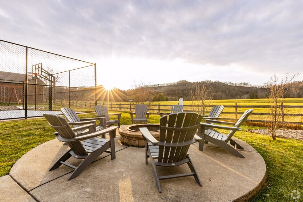 a patio with rocking chairs and a fire pit