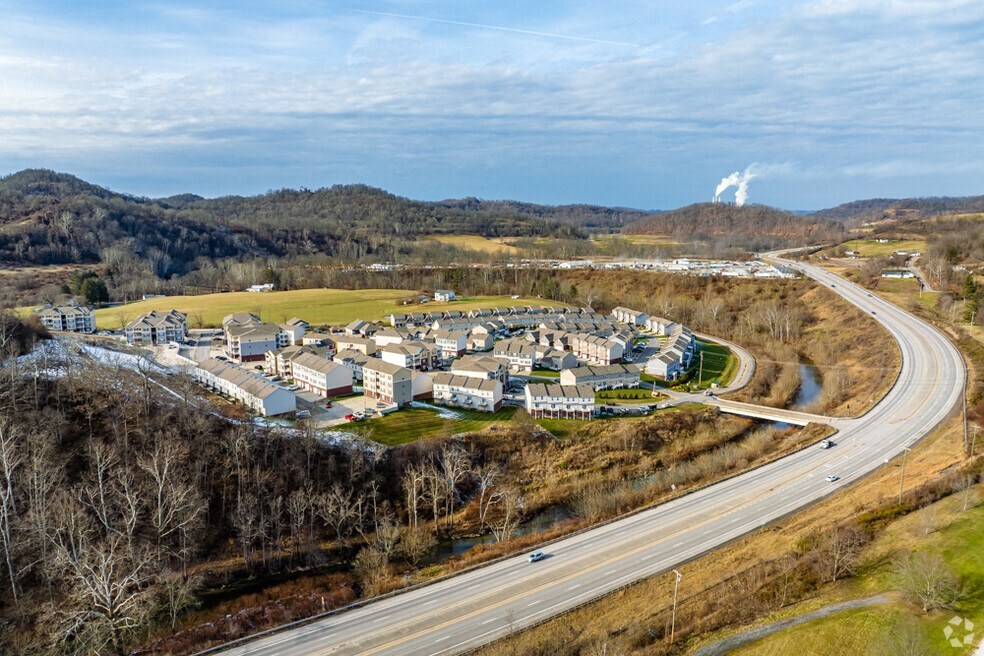an aerial view of a town with a highway and a coal plant