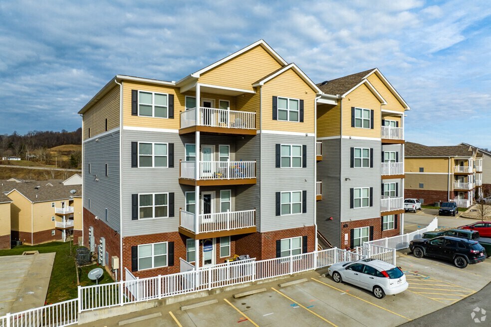 a row of apartment buildings with cars parked in front of them