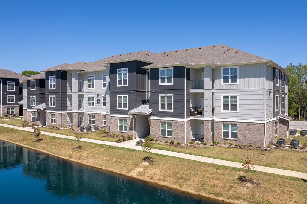 an aerial view of an apartment building next to a body of water