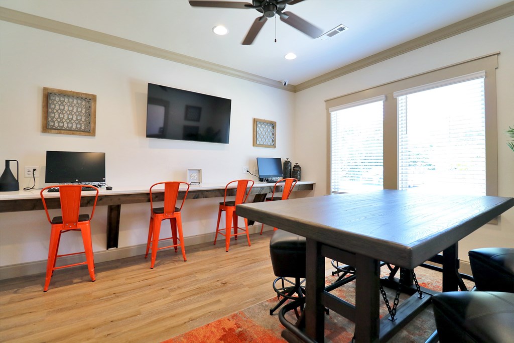 A room with a table, chairs and a television.