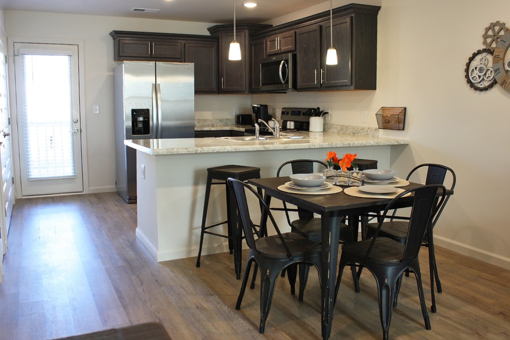 A kitchen with a table and chairs.