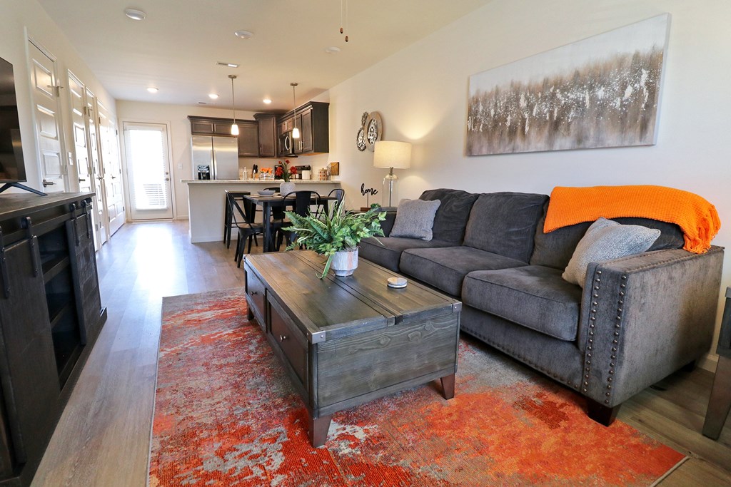 A living room with a grey couch and a wooden coffee table.