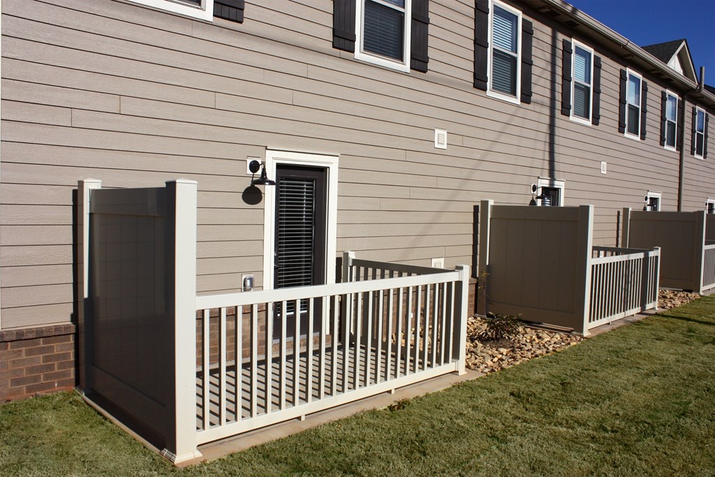 A house with a white fence and a brown siding.