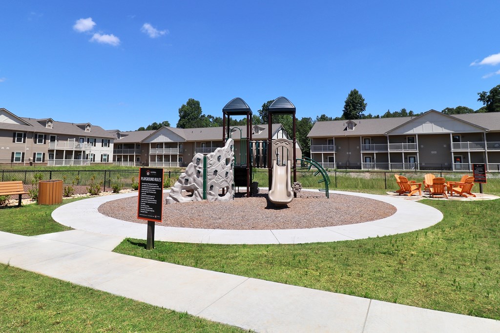 A playground with a slide and a tower in the middle of a courtyard.