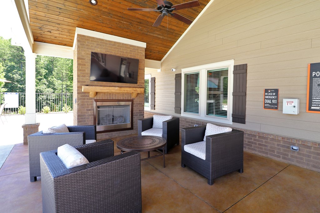 A patio with a fireplace and chairs.