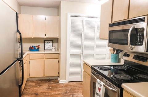 A kitchen with a refrigerator, stove, and microwave.