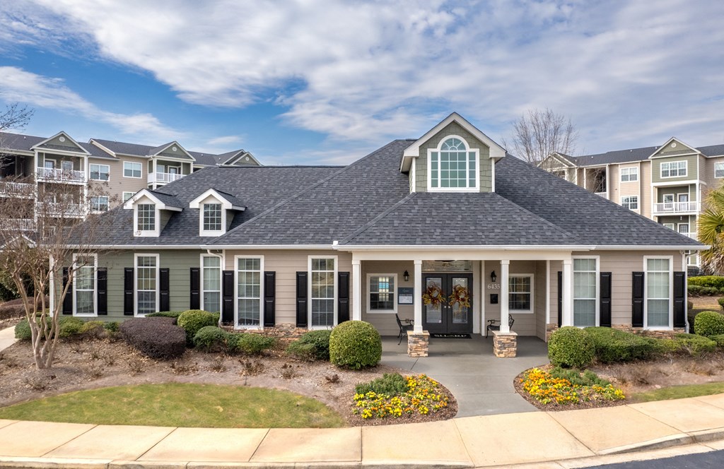 the front of a home with a large porch and a lawn