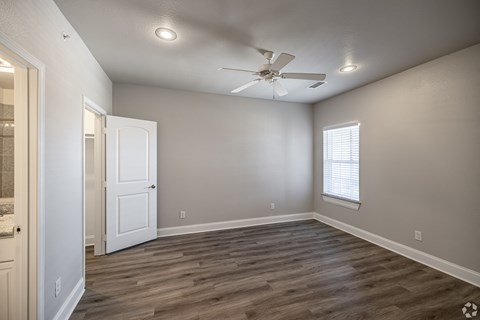 an empty room with a ceiling fan and a window