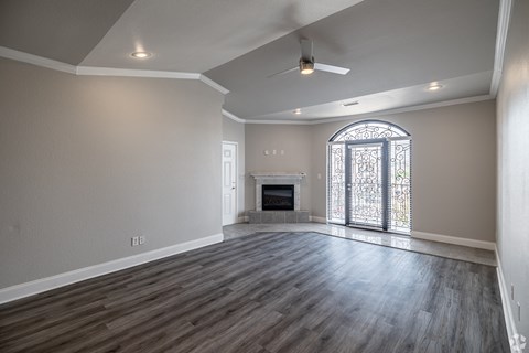 an empty living room with a fireplace and a large window