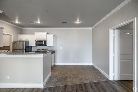 an empty kitchen with white cabinets and a counter top