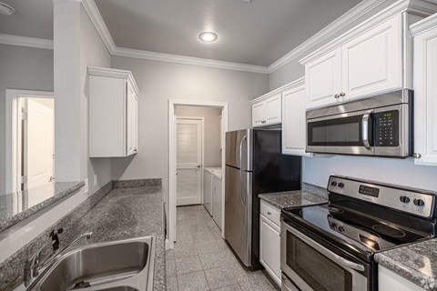 a kitchen with stainless steel appliances and white cabinets