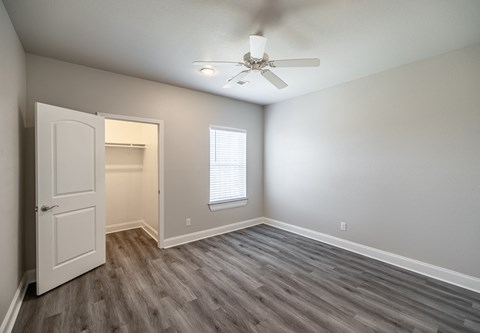 an empty room with a white door and a ceiling fan