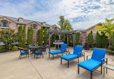 an outdoor patio with blue chairs and a gazebo
