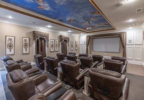 the screening room has a projector screen and leather chairs