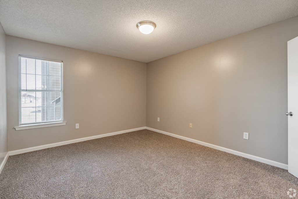 an empty room with carpet and a window