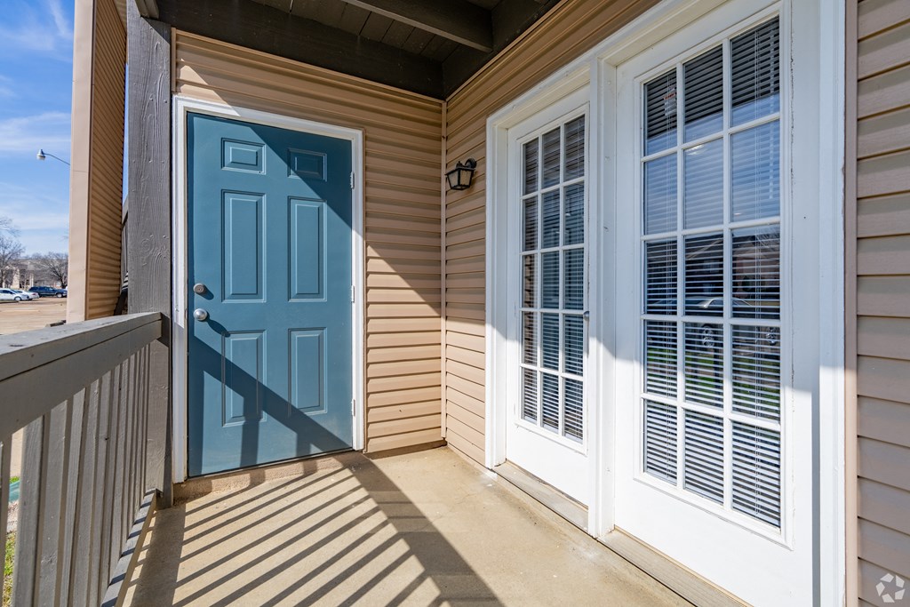 the front porch of a house with a blue door