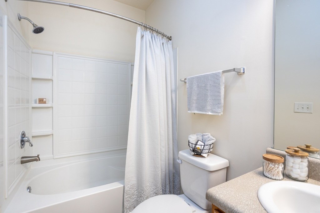 A white bathroom with a toilet, sink, and bathtub.