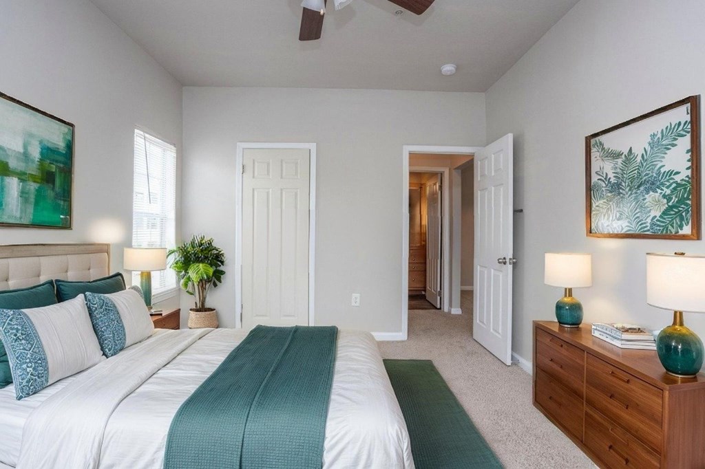 A bedroom with a large bed and a painting on the wall.