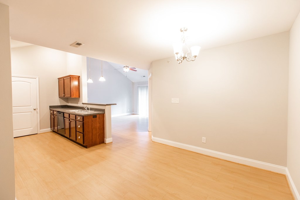 A kitchen with a wooden island and a chandelier.