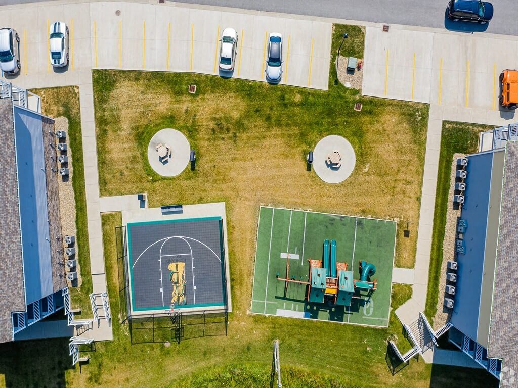 an aerial view of a football field with a soccer field and a parking lot