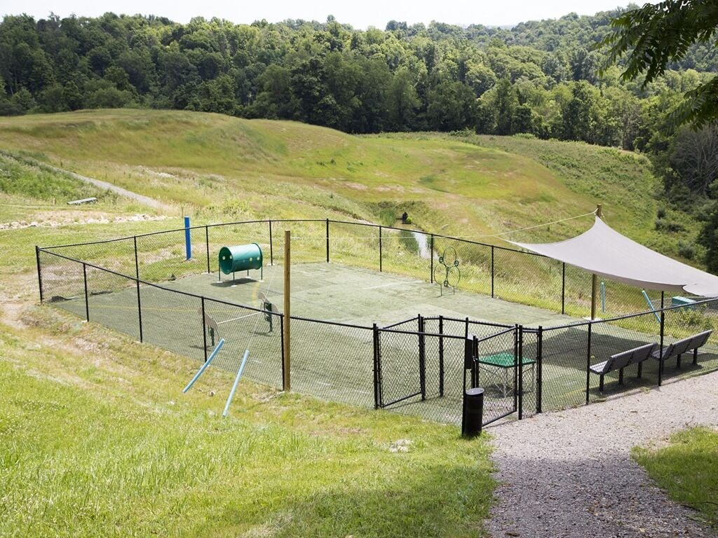a fenced in area with a tent and benches