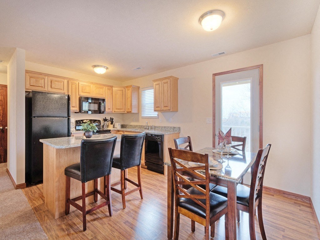 a kitchen with a breakfast bar and a table with chairs