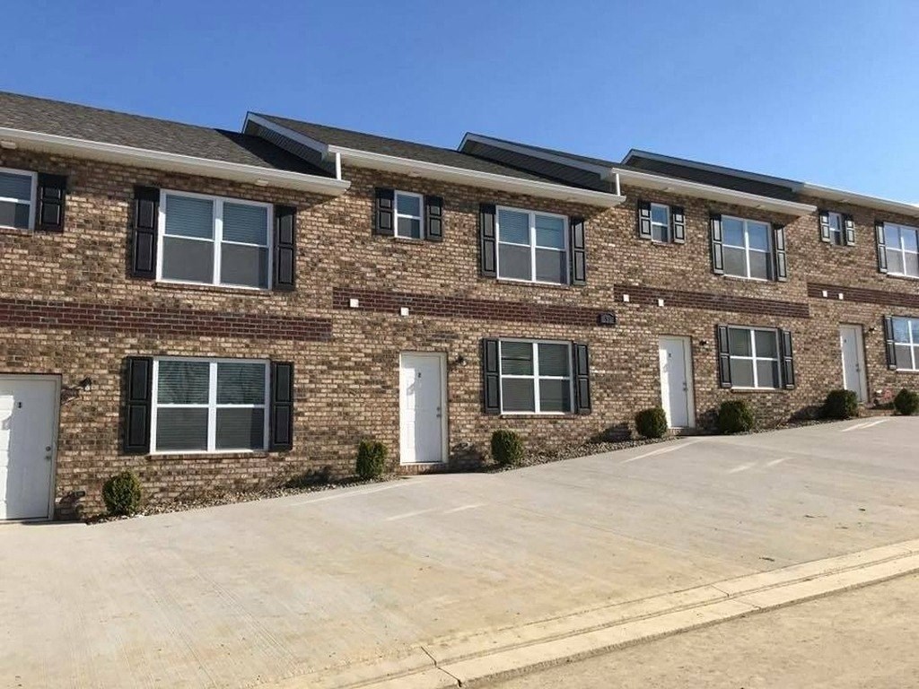 a large brick house with white doors and windows