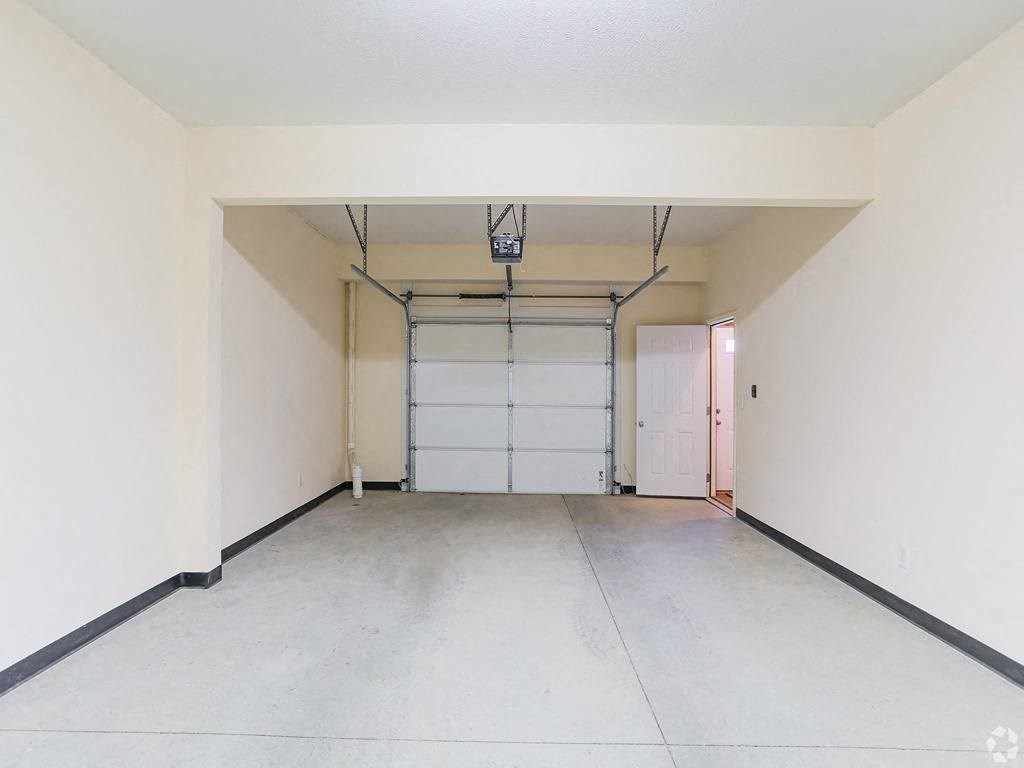 an empty garage with a white wall and a white garage door