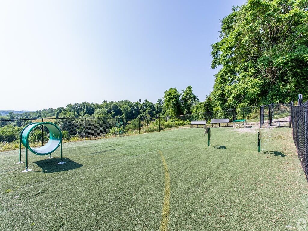 a park with a swing set and a chain link fence