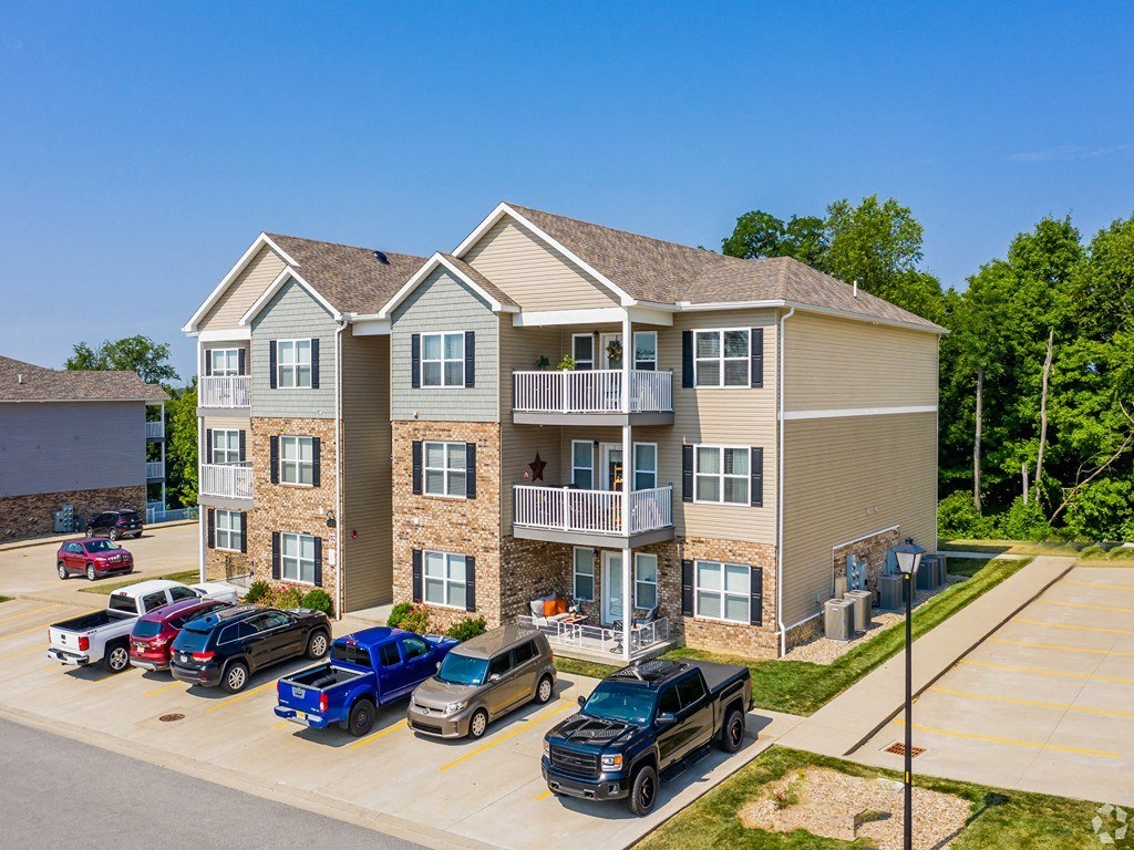 an apartment building with cars parked in front of it
