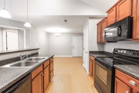 A kitchen with wooden cabinets and black appliances.