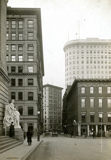 a black and white photo of a city street with tall buildings