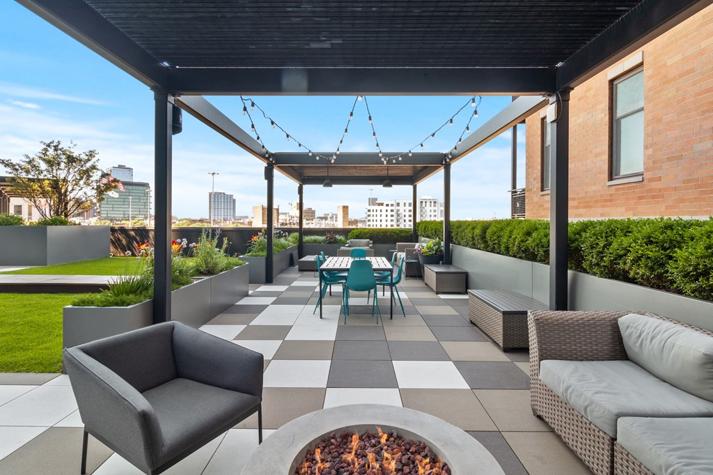 a patio with a table and chairs and a fire pit