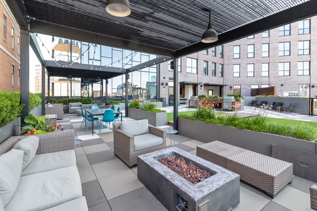 an outdoor patio with couches and chairs and a fire pit