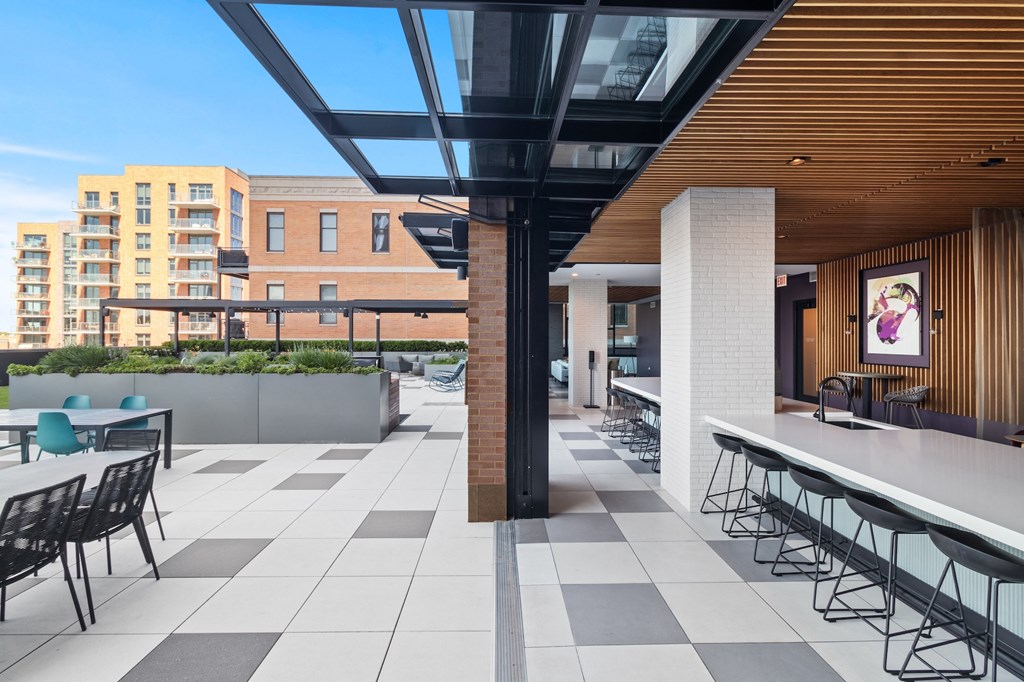 a rendering of a patio with tables and chairs and a building in the background