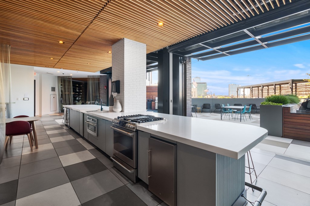 the kitchen has a large island with stainless steel appliances and a view of the city