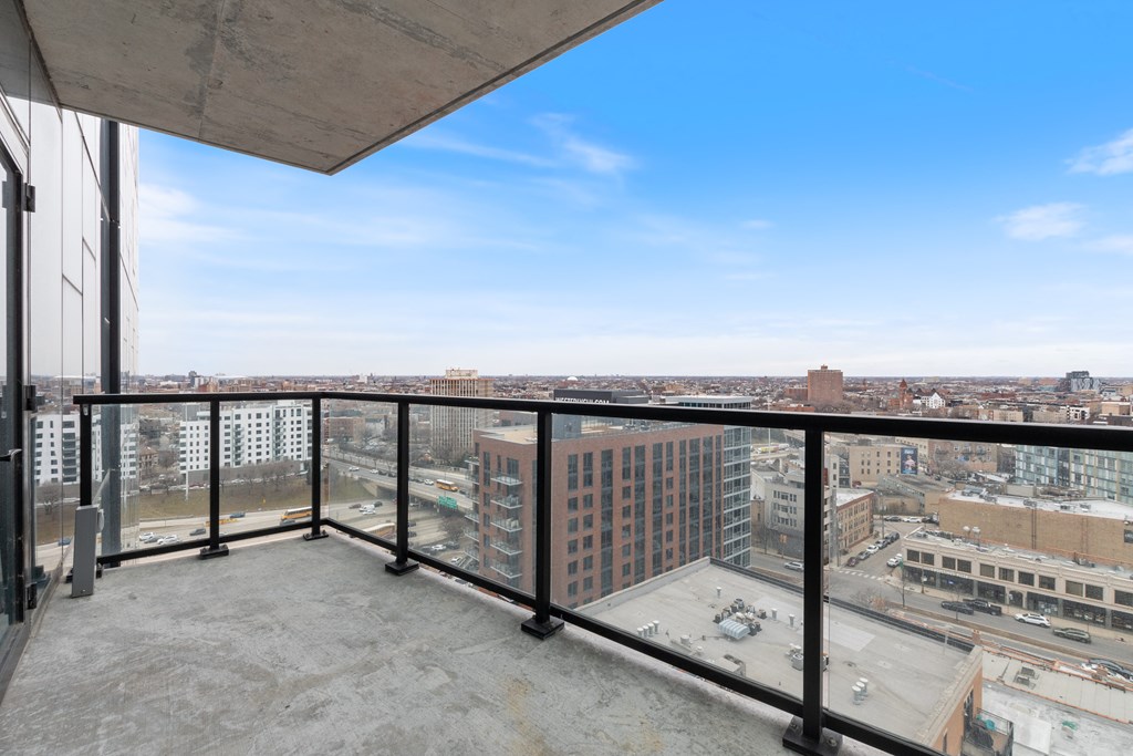 a balcony with a view of a city and a blue sky