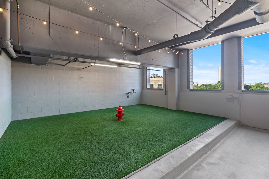 a room with artificial turf and a red fire hydrant
