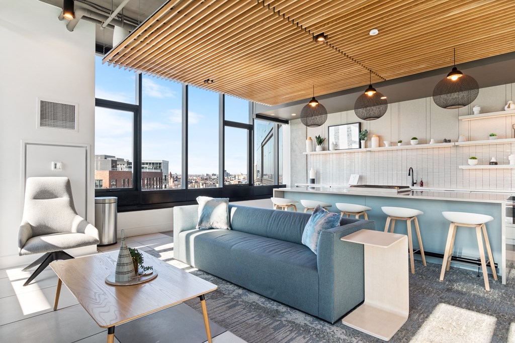 a living room with a blue couch and a kitchen with a table and chairs