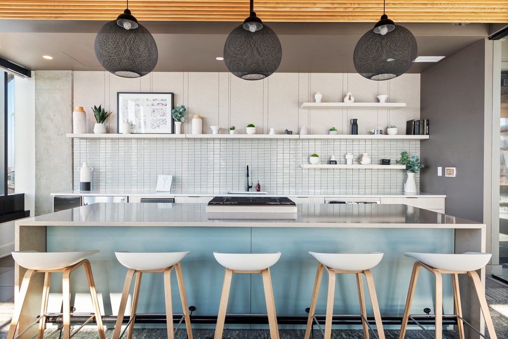 a kitchen with white stools in front of a counter top