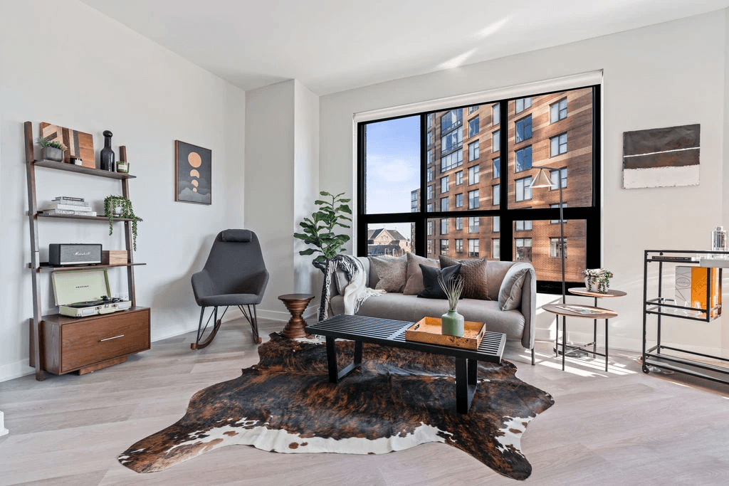 a living room with a large window and hardwood floors