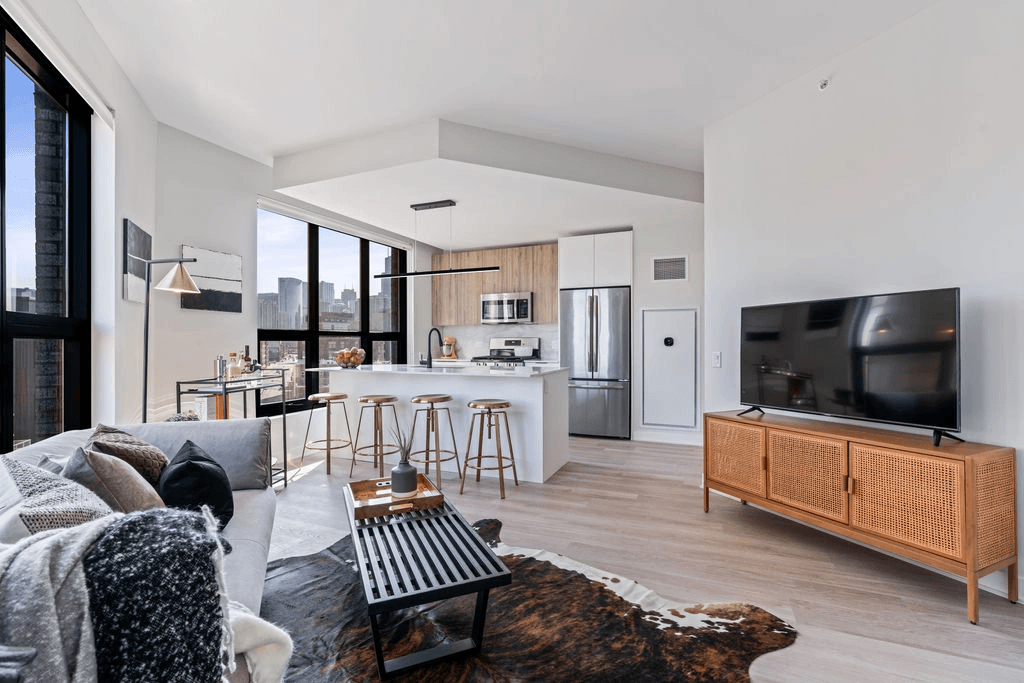 a kitchen and living room with white walls and hardwood floors
