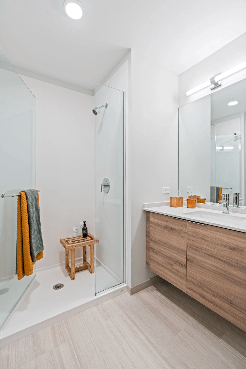 a bathroom with white walls and wood flooring