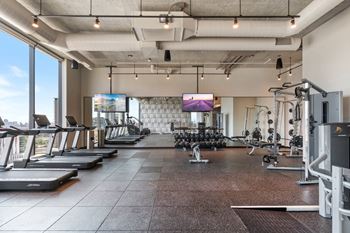 a large fitness room with treadmills and other exercise equipment