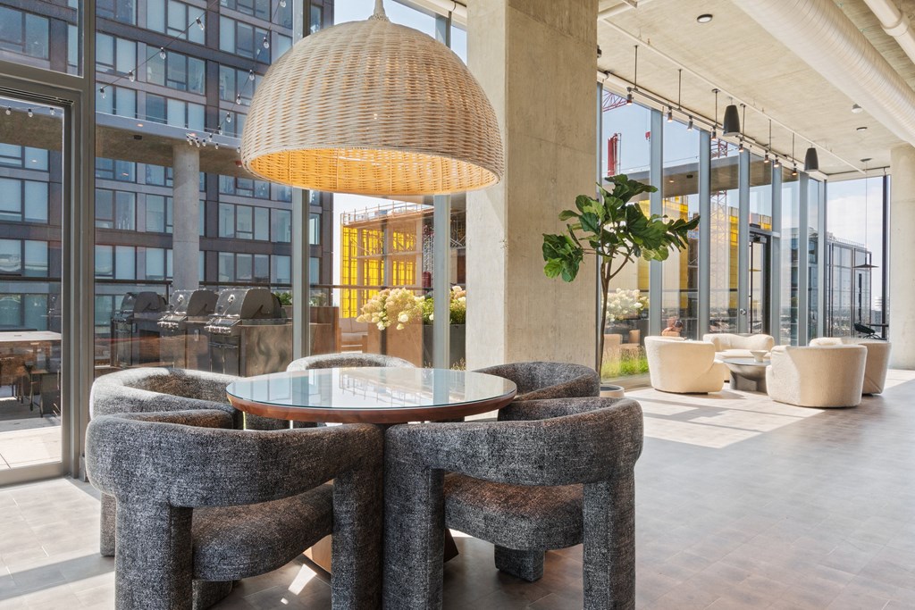 a round table with four chairs and a large pendant lamp