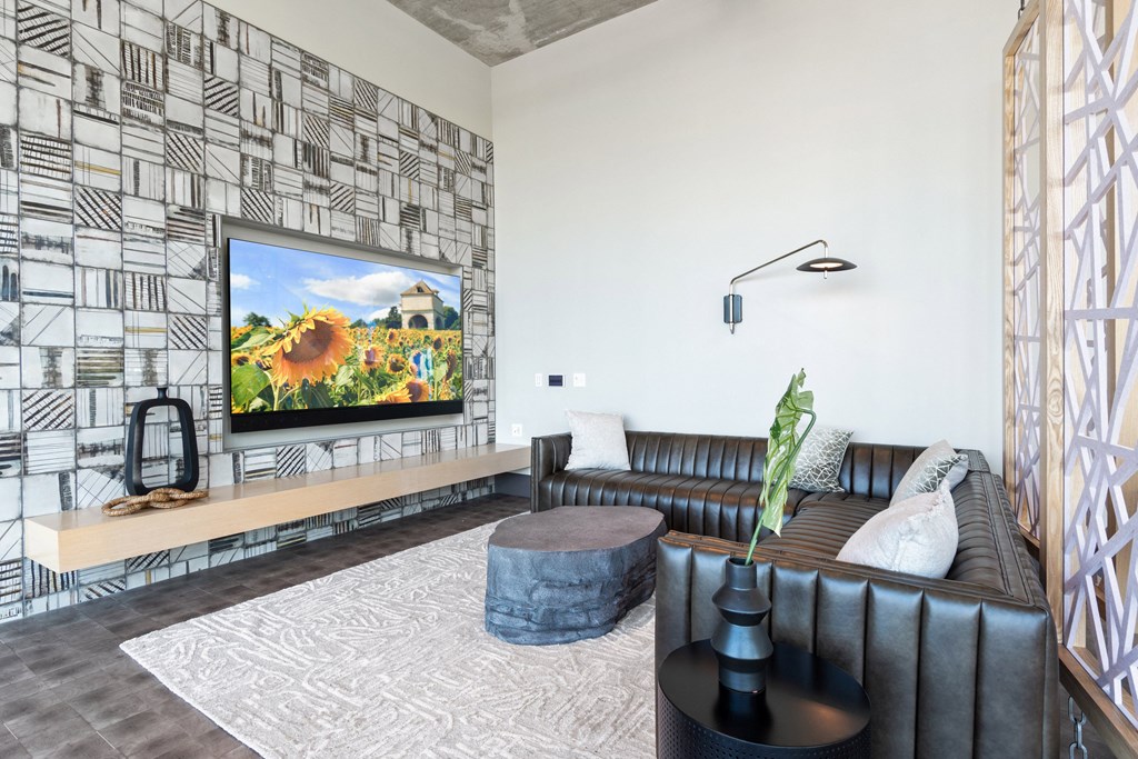 a living room with a large screen tv on the wall